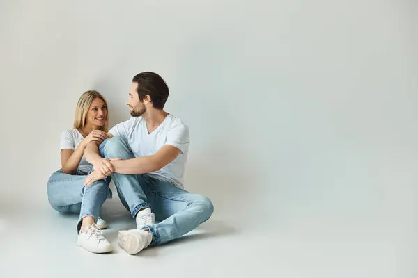 A man and a woman sit closely on the ground, absorbed in conversation, under the romantic glow of love — Stock Photo