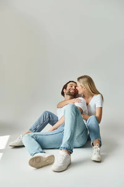 A man and a woman seated on the ground, sharing a tender moment of intimacy and connection — Stock Photo