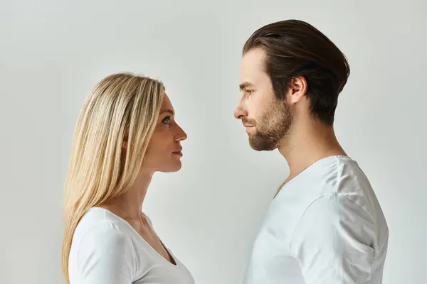Ein Mann und eine Frau, die Sehnsucht verströmen, stehen einander in einem intimen Moment intensiver Verbindung gegenüber. — Stockfoto
