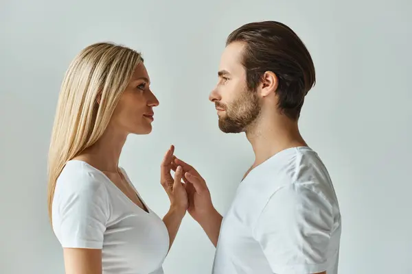 Un homme et une femme se tiennent face à face, les yeux fermés dans un moment de connexion intense et de tension romantique. — Photo de stock
