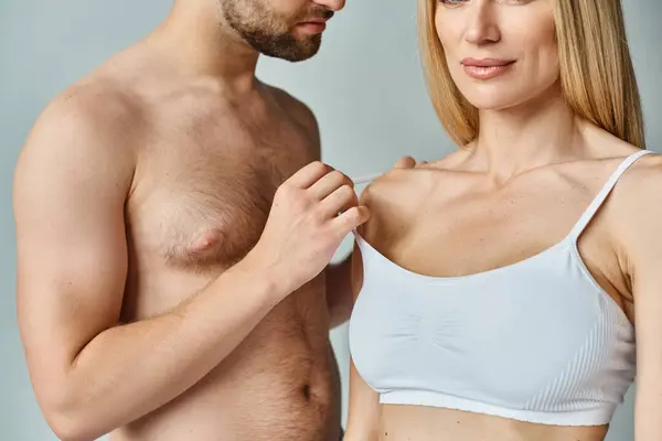 A man stands next to a woman in a white bra, exuding intimacy and sensuality in a romantic embrace. — Stock Photo