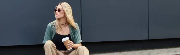 Uma mulher sentada no chão, saboreando uma xícara de café em um momento sereno ao ar livre. — Fotografia de Stock