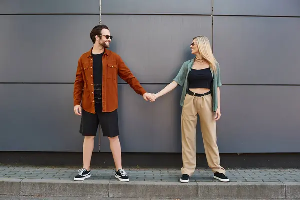 A man and woman stand side by side, hands clasped, exuding an aura of romance and unity. — Stock Photo