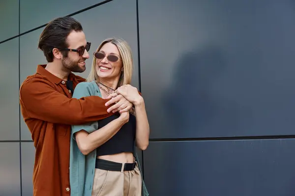 Ein sexy Paar mitten in der Romanze, innig umarmt vor einer strukturierten Wand. — Stockfoto