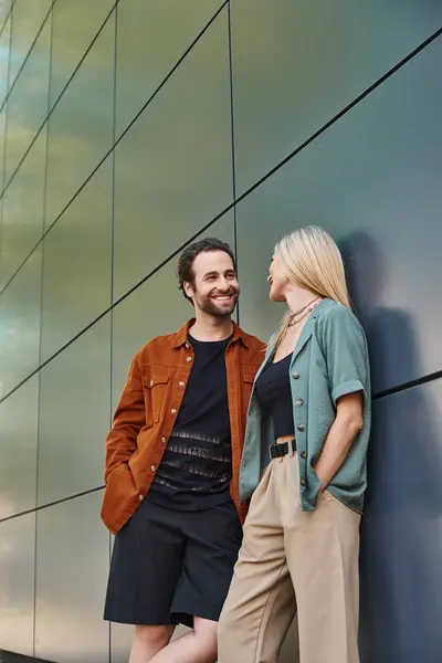 A romantic couple leaning against a wall, sharing a private moment together. — Stock Photo