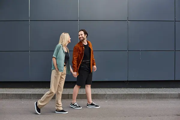 A sexy couple, exuding romance, strolls down a bustling city street. — Stock Photo