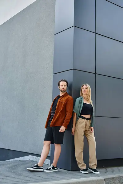 Una coppia sexy in piedi insieme all'ombra di un edificio alto, trasudando un senso di romanticismo urbano e di connessione. — Foto stock