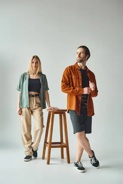Una sexy pareja de pie junto a un taburete, mostrando su romance y conexión en un entorno sencillo pero íntimo. - foto de stock