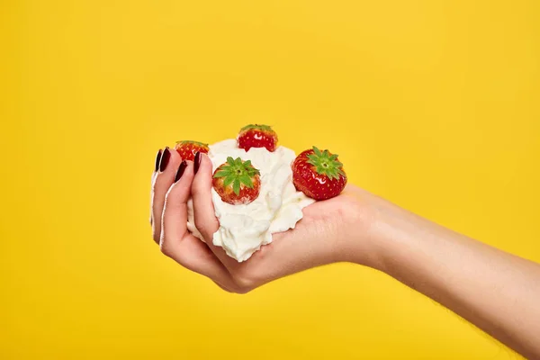 Objektfoto von köstlichen süßen roten Erdbeeren in Schlagsahne in den Händen einer unbekannten Frau — Stockfoto