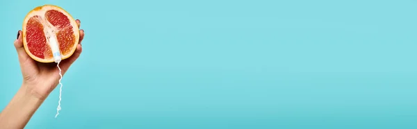 Objet photo de pamplemousse frais avec tampon en main de femme inconnue sur fond bleu, bannière — Photo de stock