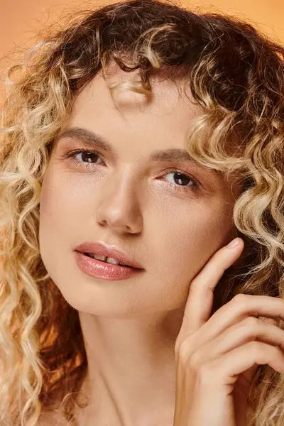 Close up portrait of curly woman with natural makeup and perfect skin looking at camera in studio — Stock Photo