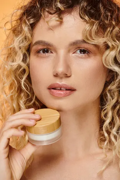 Close up portrait of attractive woman with natural makeup and clean skin posing with face cream — Stock Photo