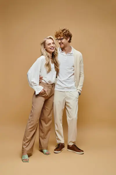 Pleine longueur de couple gai en vêtements décontractés souriant sur beige, mode classique intemporelle — Photo de stock