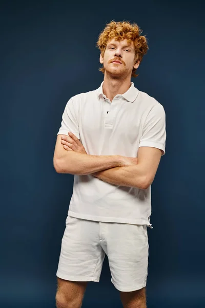 Confident redhead man in white stylish clothes with folded arms on blue, old money style fashion — Stock Photo