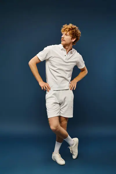 Homme à la mode bien habillé en short blanc et t-shirt polo regardant loin sur bleu, pleine longueur — Photo de stock