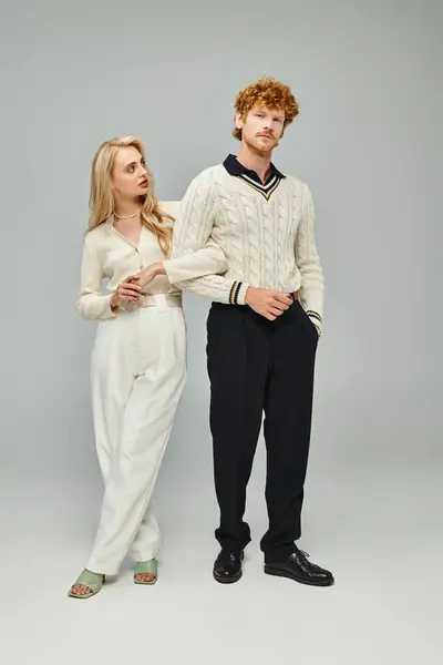 Full length of young couple in fashionable attire posing on grey backdrop, old money style concept — Stock Photo