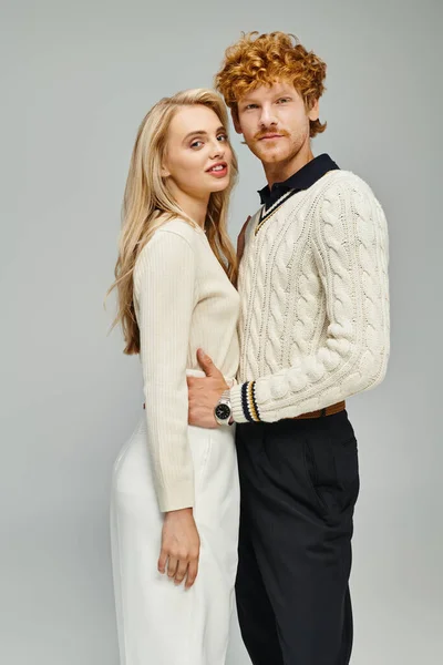 Redhead man and blonde woman in trendy casual clothes looking at camera on grey, classic fashion — Stock Photo