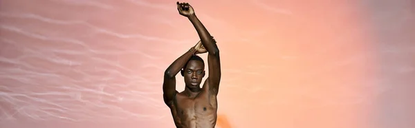 Good looking fashionable african american man posing topless surrounded by red lights, banner — Stock Photo