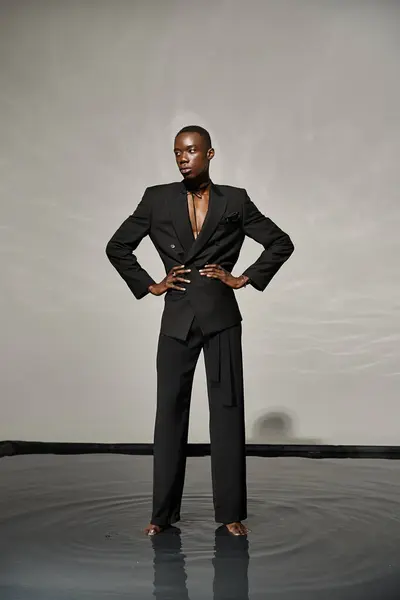Verführerisch stilvolle afrikanisch-amerikanische Mann in sexy geknöpften Anzug posiert auf grauen wässrigen Hintergrund — Stockfoto