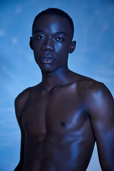 Tempting shirtless african american man in fashionable jeans looking at camera on watery backdrop — Stock Photo