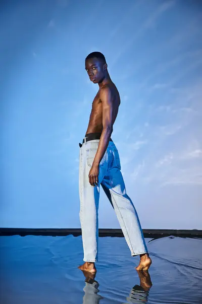 Handsome shirtless african american man in blue jeans looking at camera on watery background — Stock Photo