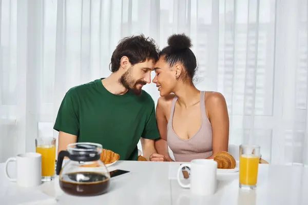 Alegre casal multicultural boa aparência posando amorosamente juntos durante seu café da manhã em casa — Fotografia de Stock