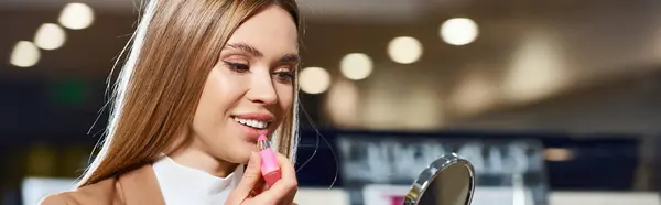 Séduisante femme en tenue d'affaires en choisissant un nouveau rouge à lèvres tandis que dans le magasin de cosmétiques, bannière — Photo de stock