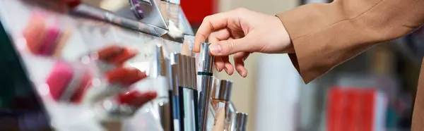 Cropped view of sophisticated female customer choosing new mascara while in cosmetics store, banner — Stock Photo