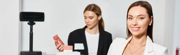 Freudig schöne Kundin blickt in Kamera neben Verkäuferin in Kosmetikgeschäft, Banner — Stockfoto