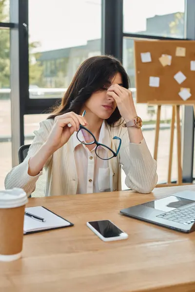 Une femme d'affaires concentrée sur son ordinateur portable dans un espace de bureau moderne, reflétant le concept de franchise. — Photo de stock