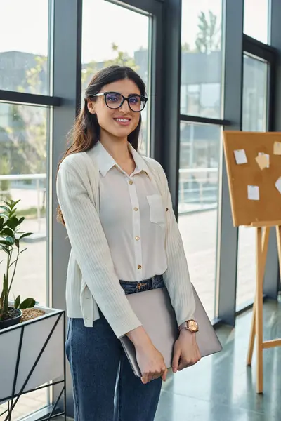 A businesswoman stands confidently in front of a window — Stock Photo