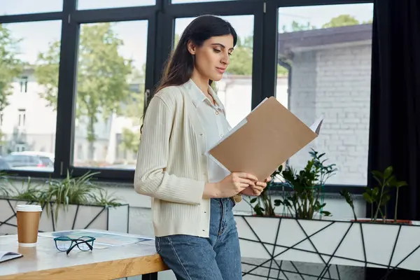 A businesswoman confidently holds a clipboard in a modern office, embodying efficiency and professionalism. — Stock Photo