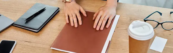 Uma mulher de negócios em um escritório moderno é profundamente absorvido, as mãos descansando em um livro, refletindo um compromisso com o conhecimento e crescimento. — Fotografia de Stock