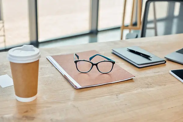 Modernes Büro mit Holztisch, Notizbuch und einer Tasse Kaffee. — Stockfoto
