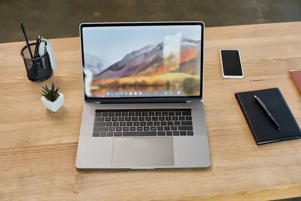Una computadora portátil descansa sobre una mesa de madera en un entorno de oficina moderno, destacando el concepto de un espacio de trabajo digital. - foto de stock
