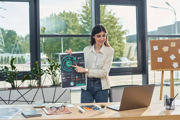 A businesswoman stands confidently in a modern office, holding up a sign to convey her message in a franchise concept setting. — Stock Photo