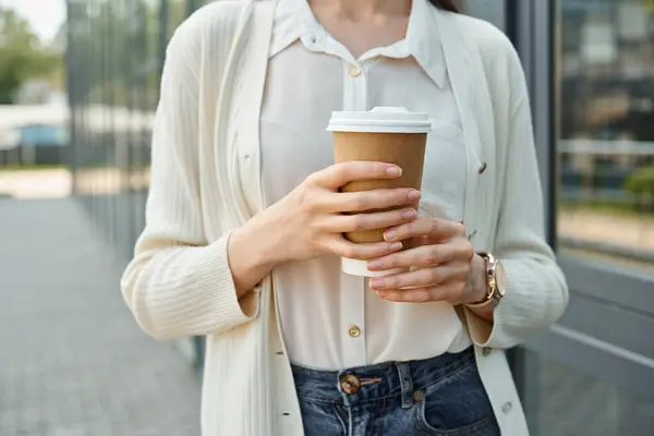 Бізнес-леді насолоджується спокійним моментом на відкритому повітрі, тримаючи чашку кави. — стокове фото