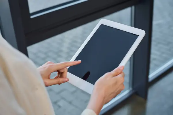 Una mujer de negocios en una oficina moderna tiene confianza e interactúa con una tableta, encarnando el concepto de franquicia. - foto de stock