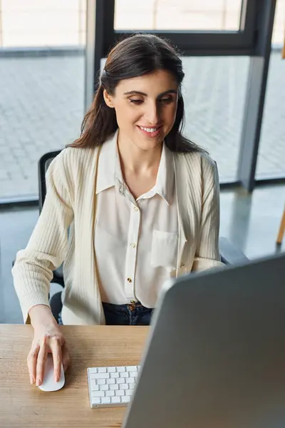 A businesswoman immersed in her work at a modern office desk, utilizing a computer to navigate through franchise concepts. — Stock Photo