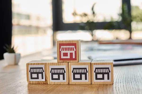 Ein Holzblock mit einem Miniaturladen an der Spitze, der ein kreatives Franchise-Konzept in einem modernen Büroambiente darstellt. — Stockfoto