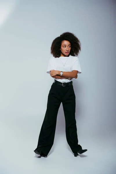 Buon trendsetter afroamericano dall'aspetto elegante con capelli ricci che distolgono lo sguardo, moda — Foto stock