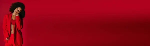 Appealing sexy african american woman in vibrant attire looking at camera on red backdrop, banner — Stock Photo