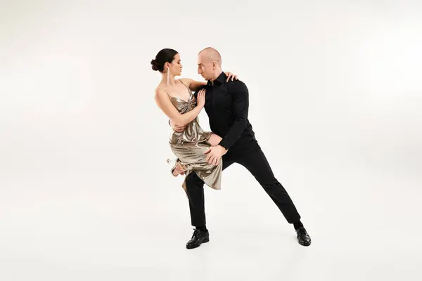 Un joven y una mujer bailan juntos acrobáticamente en perfecta sincronía contra un fondo de estudio blanco. - foto de stock
