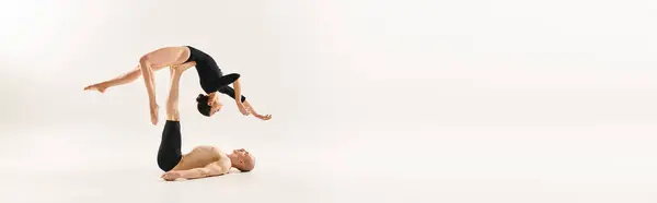 Una mujer y un hombre demuestran un equilibrio impresionante haciendo elemento acrobático. - foto de stock