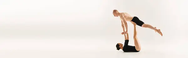 Jeune homme et femme torse nu exécutant des poignées synchronisées dans un cadre de studio sur un fond blanc. — Photo de stock