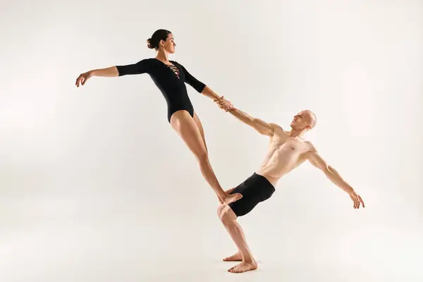 Jeune homme et jeune femme torse nu exécutent des mouvements de danse acrobatique sur fond blanc. — Photo de stock