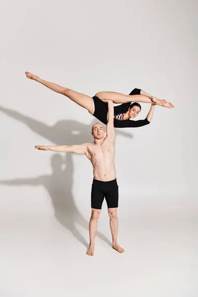 Молодий чоловік і жінка без сорочки виконують акробатичну гармонію перед білим тлом. — стокове фото
