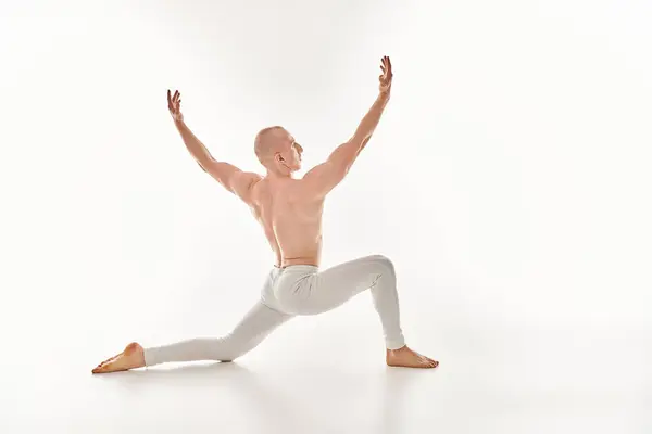 Ein junger Mann tanzt anmutig mit Präzision und Gleichgewicht in einem Studio auf weißem Hintergrund. — Stockfoto