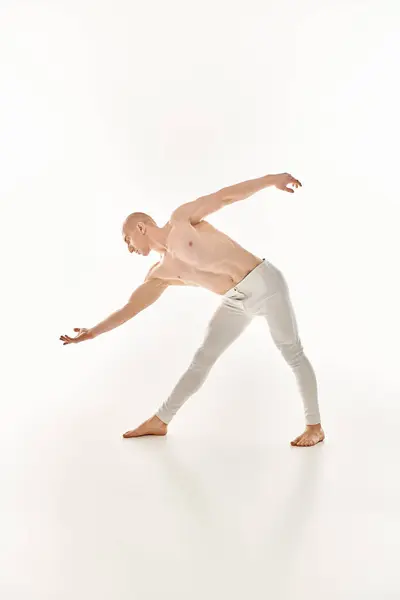 A young man showcases acrobatic dance moves with precision and fluidity in a studio setting against a white background. — Stock Photo