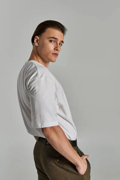 Appealing sophisticated man in elegant attire with brown pants posing and looking at camera — Stock Photo